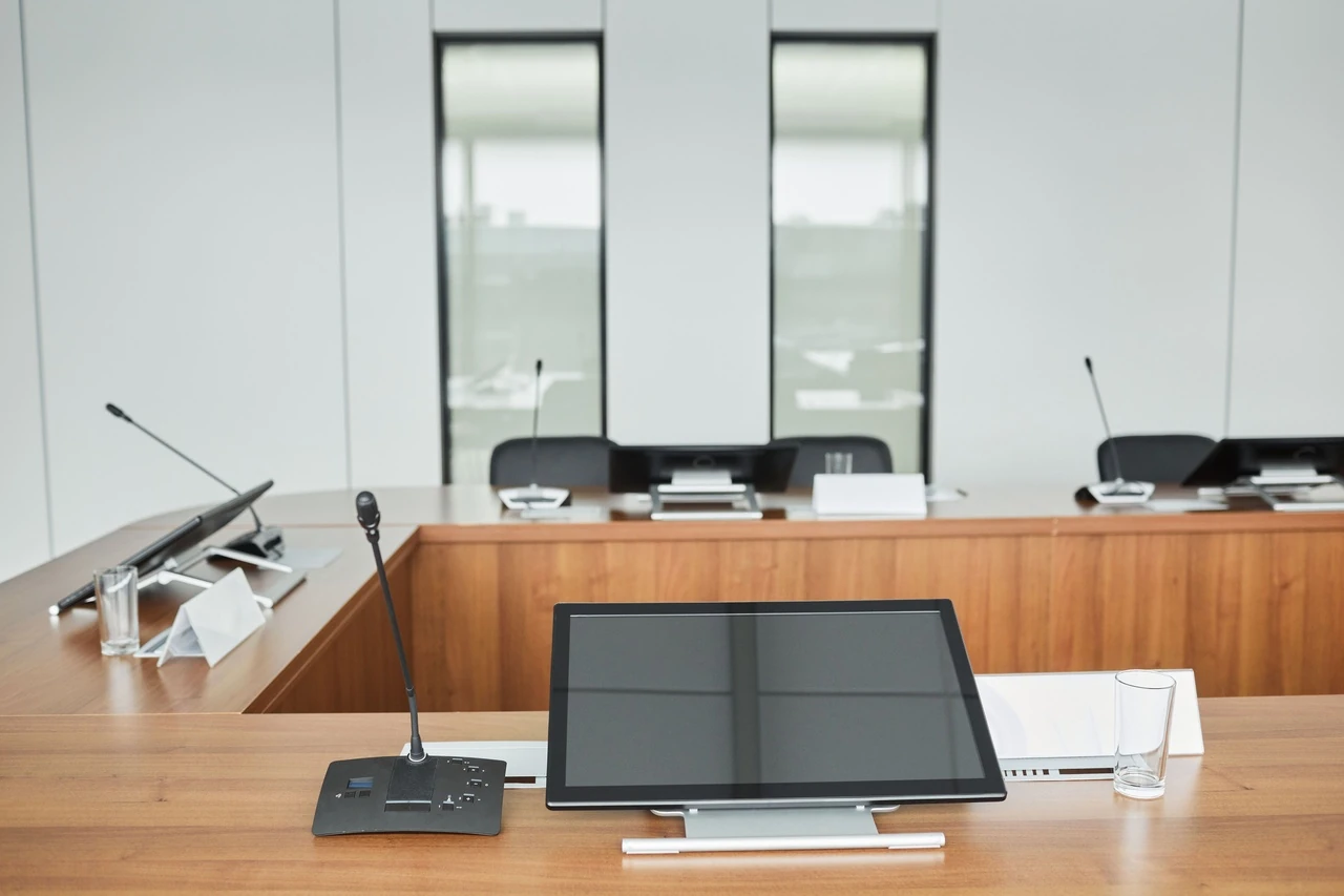 Hearing room table with microphones and tablets at each seat