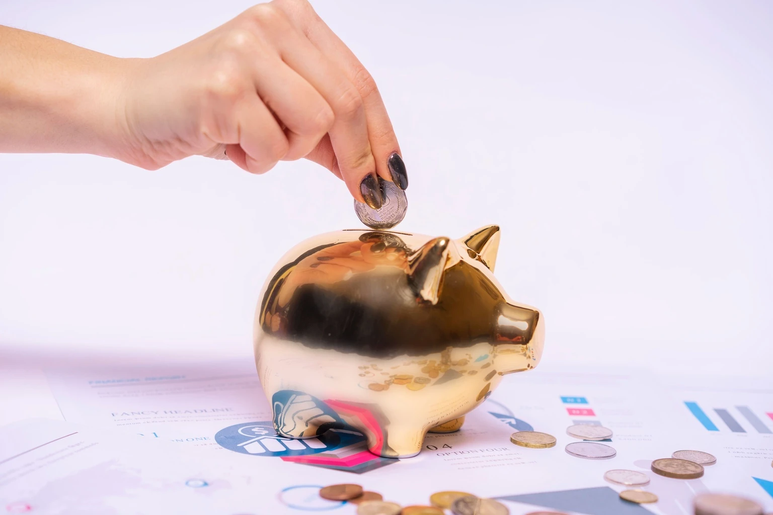 Hand placing a coin into a gold piggy bank