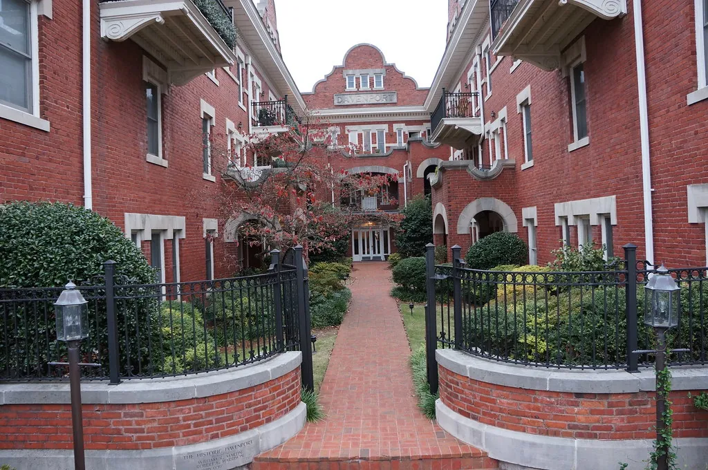 Brick condo building with a landscaped courtyard and iron entry gate